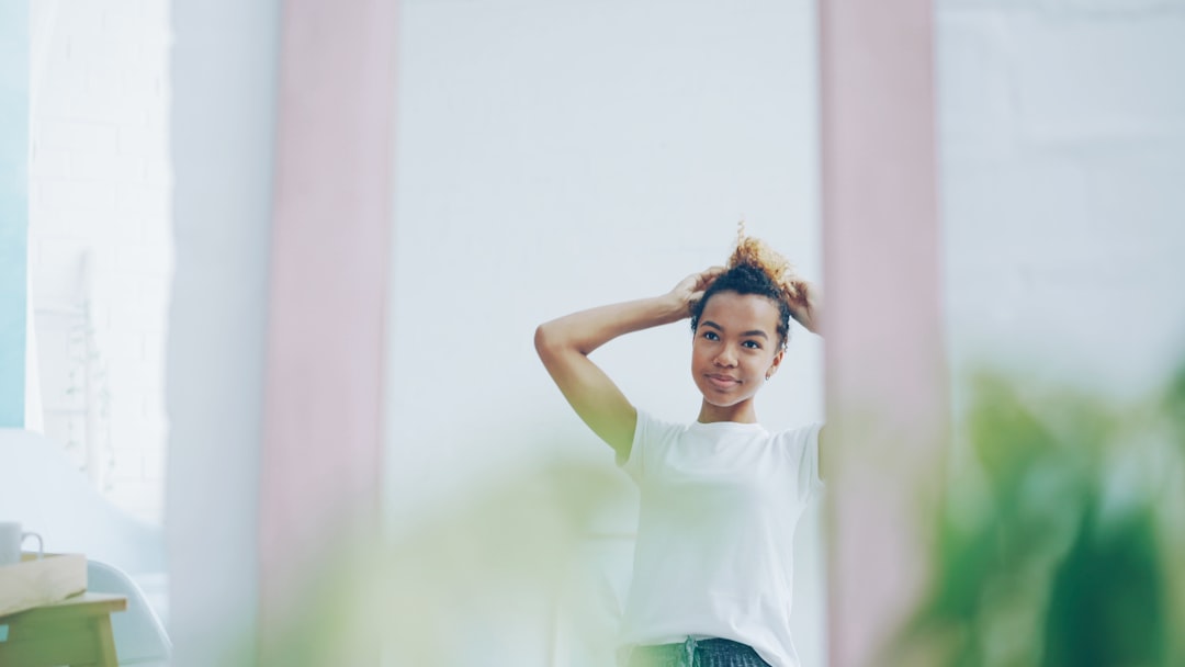 Woman styling her hair in a mirror.