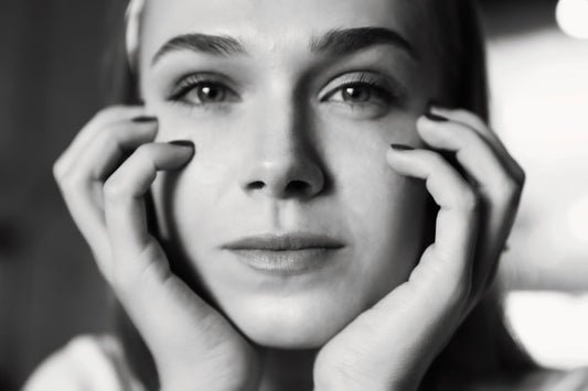 a black and white photo of a woman holding her hands to her face