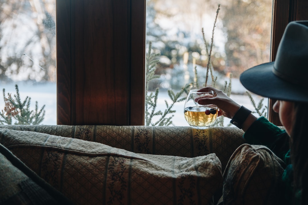 A woman sitting on a couch in front of a window