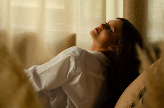 A woman laying on a couch with her eyes closed