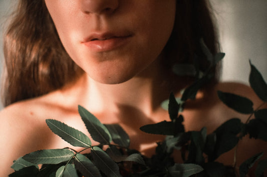 woman in black shirt holding green leaves