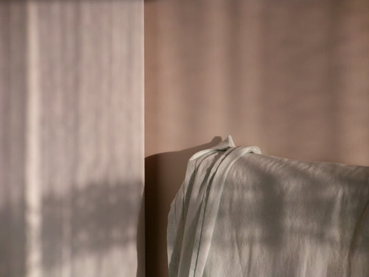 Soft fabric draped with dappled light patterns.